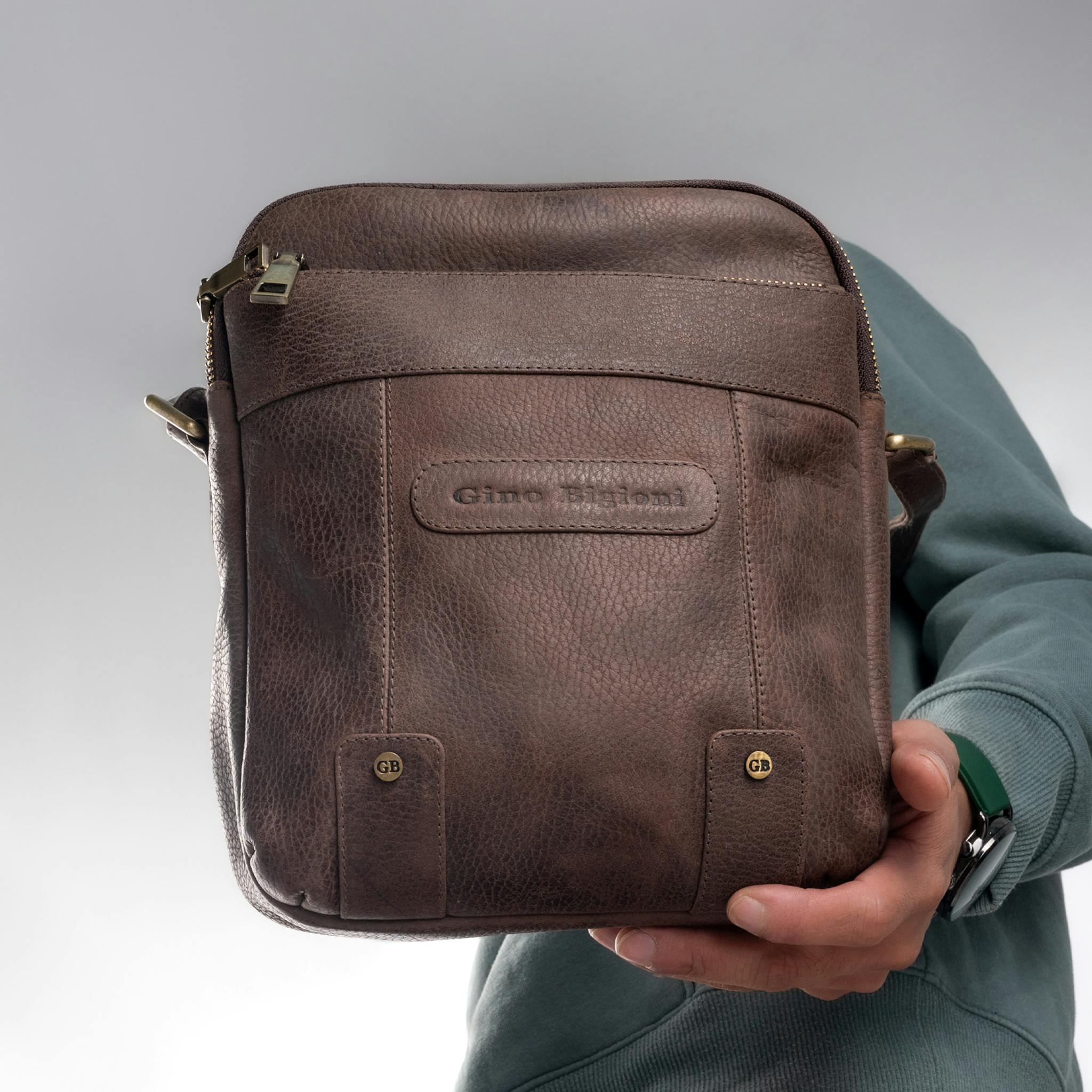 Stylish Gino Bigioni leather shoulder bag showcased by hand for modern fashion lovers.